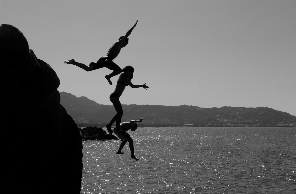 three children jumping into water